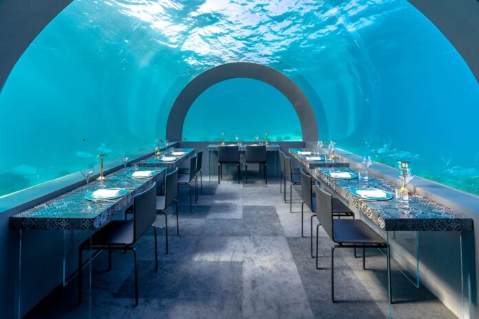 Goście w luksusowej podwodnej restauracji z widokiem na ocean