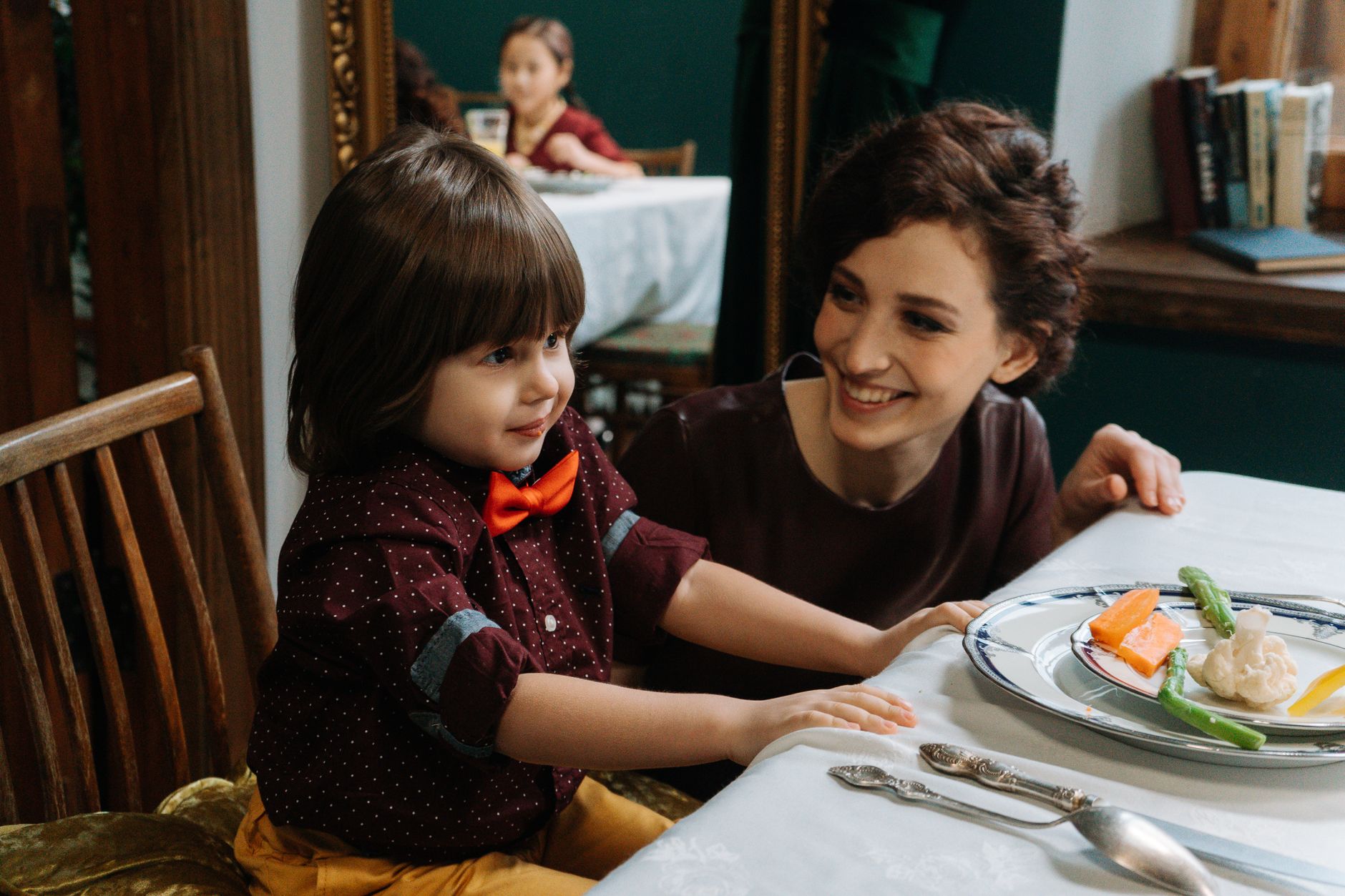 Mama z synem uśmiechają się przy zdrowym posiłku w eleganckiej restauracji