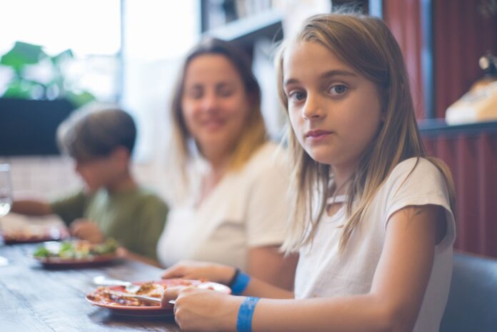 Rodzina w restauracji podczas posiłku, w centrum uwagi kilkuletnia dziewczynka Rodzina w restauracji podczas posiłku, w centrum uwagi kilkuletnia dziewczynka