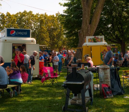Tłum ludzi na plenerowym festiwalu food trucków w parku
