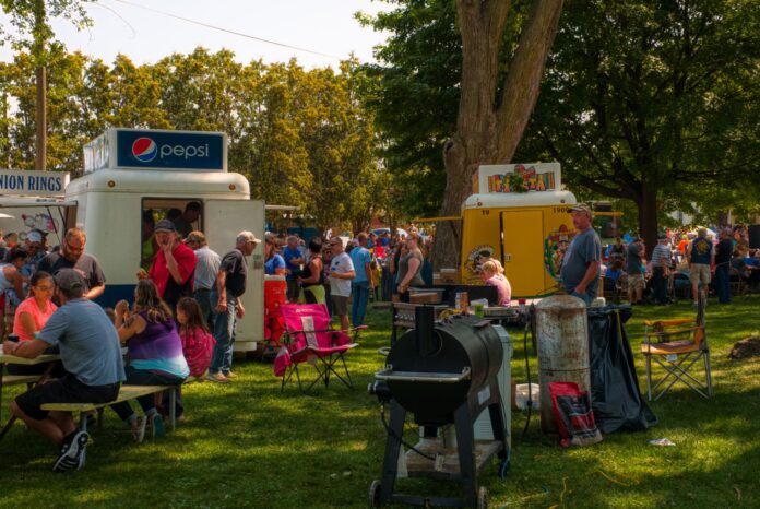 Tłum ludzi na plenerowym festiwalu food trucków w parku Tłum ludzi na plenerowym festiwalu food trucków w parku